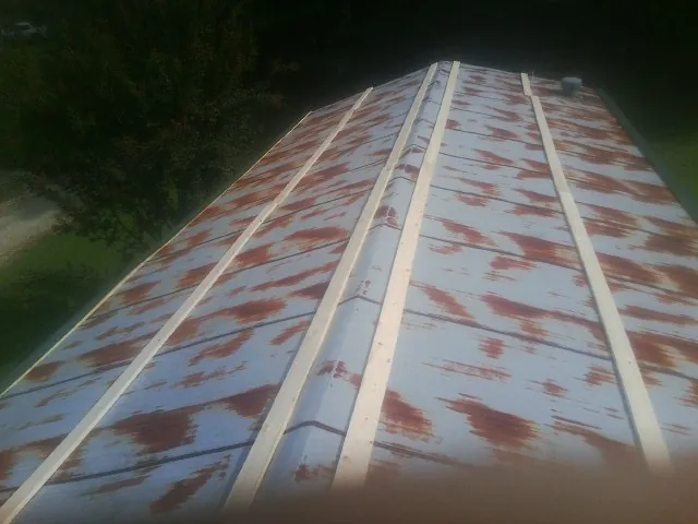 Rusted metal roof panels with new wood purlins before replacement — Storm Damage Roof Repair in Cogswell by Roofing Brothers