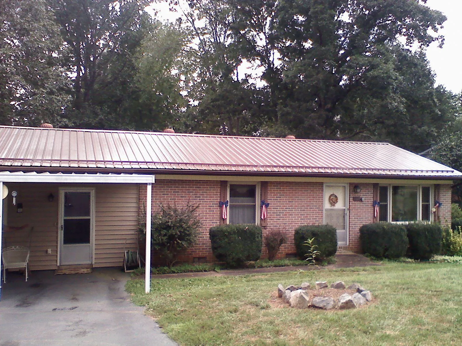 Bronze metal roof and carport on a brick ranch home — Roof Repair work by our crew in Cogswell