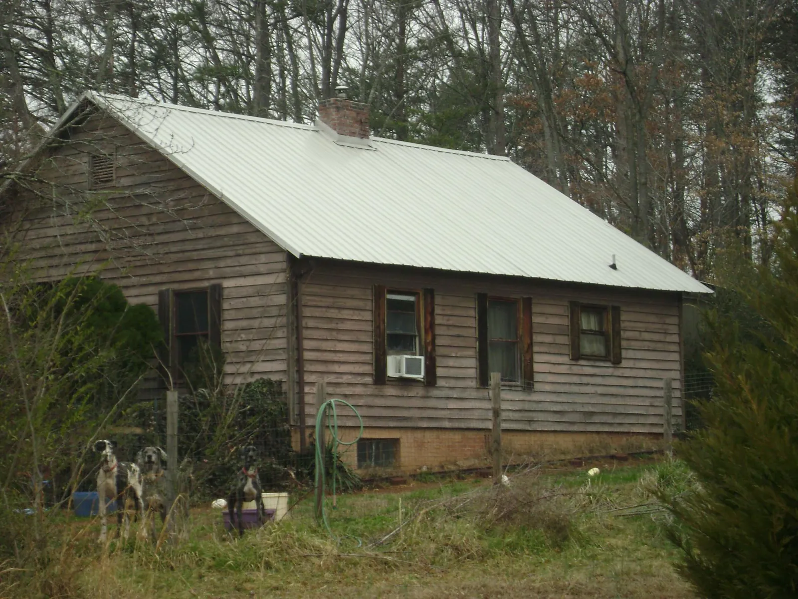 White metal roof on an old wood sided farmhouse, from a Metal Roof Installation job in Cogswell